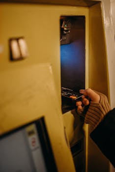 Close-up of a person inserting a card into a public transport ticket machine.